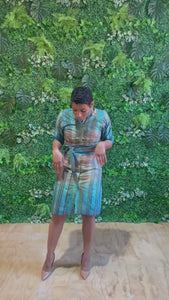 Video of LOVE DOT's Ramya Batik Knee length shirt dress. Dress is handmade in Accra, Ghana, 100% Cotton, and features an abstract aqua green and blue striped pattern.